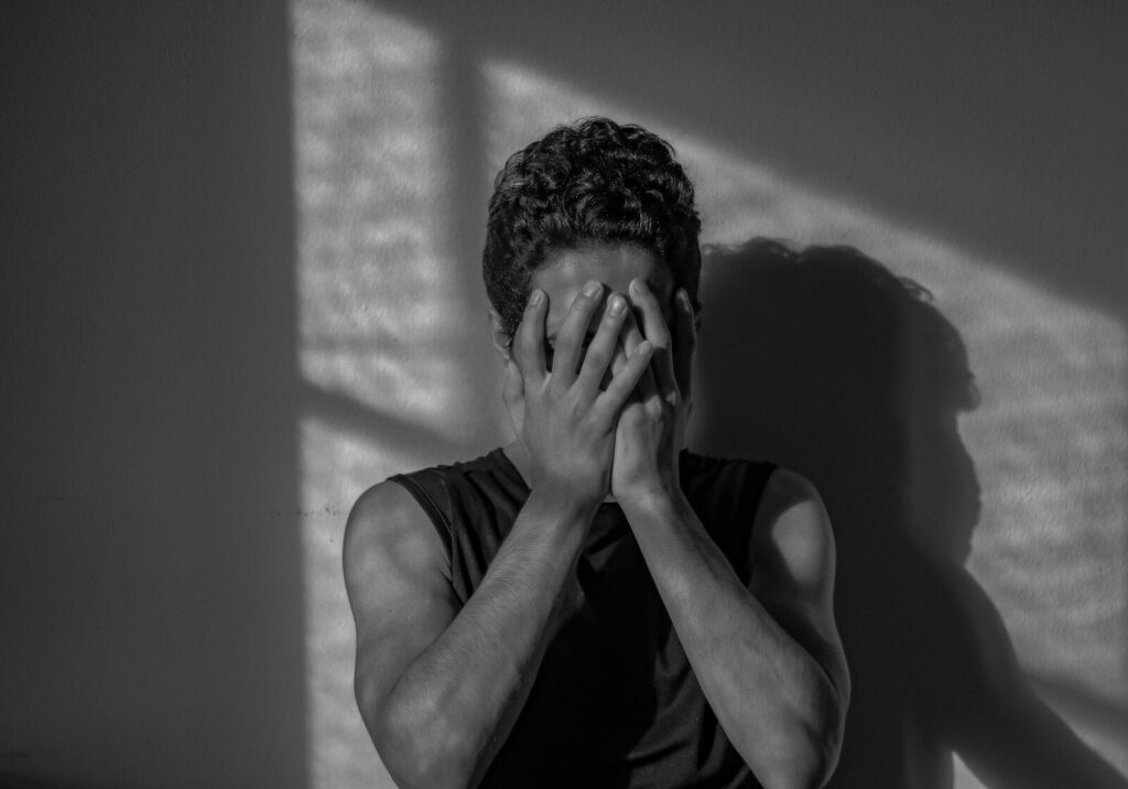 a man covering his face with his hands